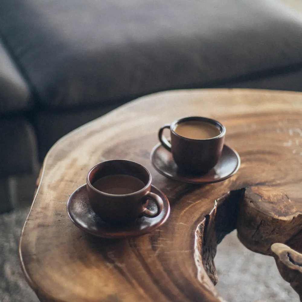 Consulting - Two brown coffee cups sitting on a wooden table